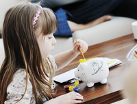 Společnost MOPET CZ přichází s platební kartou, která učí děti hospodařit. Na snímku holčička s rodiči.